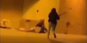 teen girl running to hit homeless woman with a bat-like object