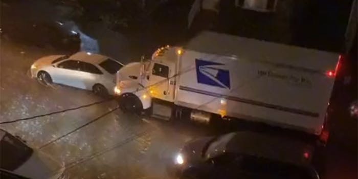 USPS truck pushes car through flooded street