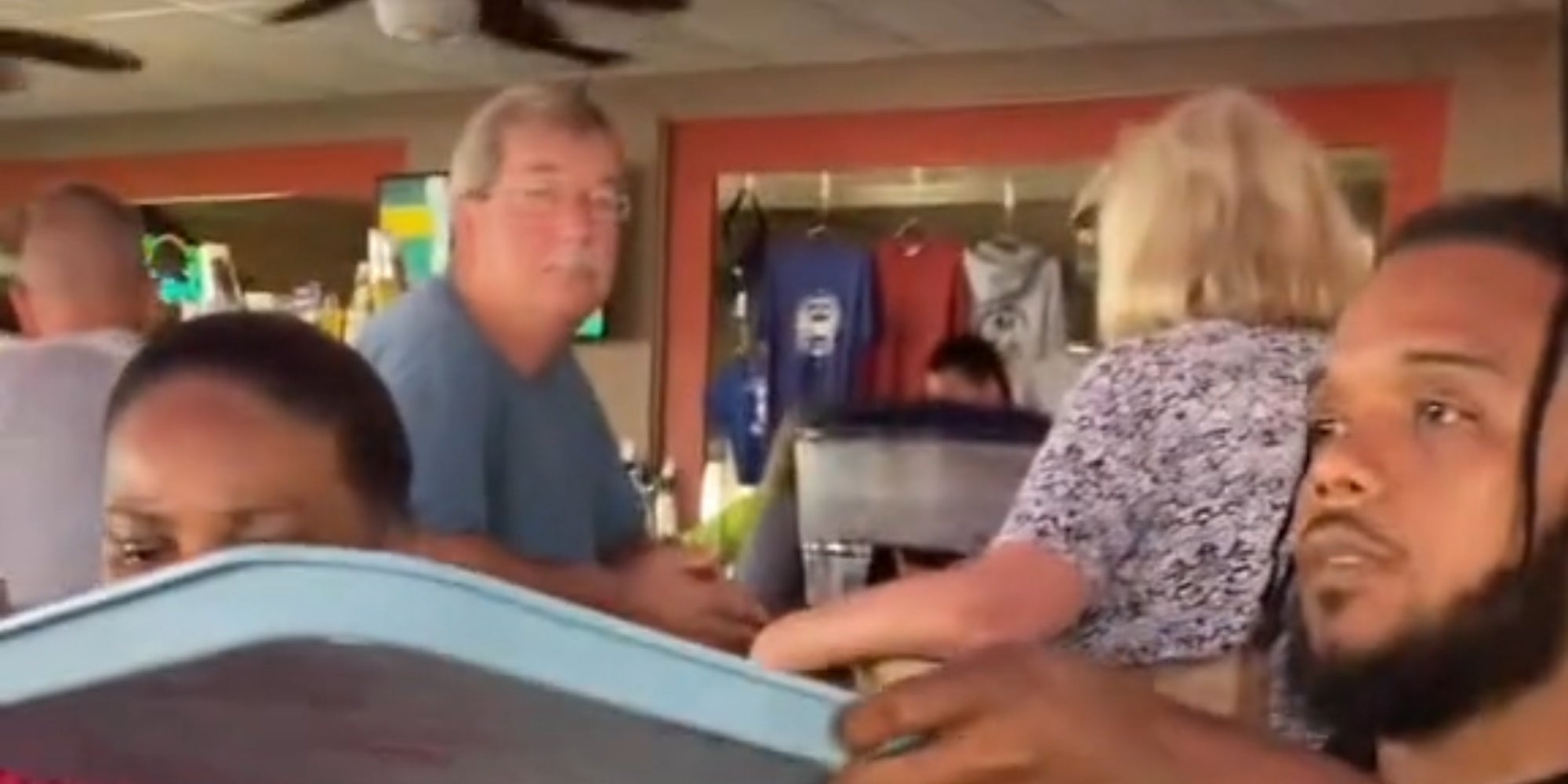 white man staring at Black family while they eat