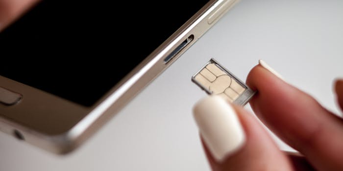 A person replacing a SIM card on a cell phone.