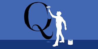 Man painting over a giant Q