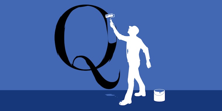 Man painting over a giant Q