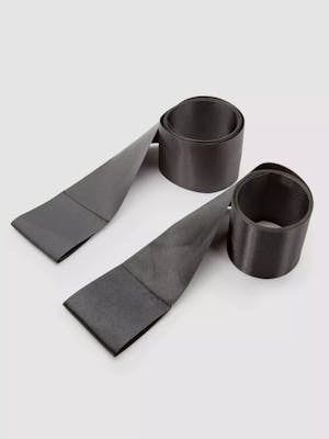 Two black rolls of silk bondage restraints