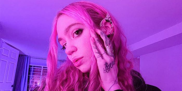 Grimes touches her face