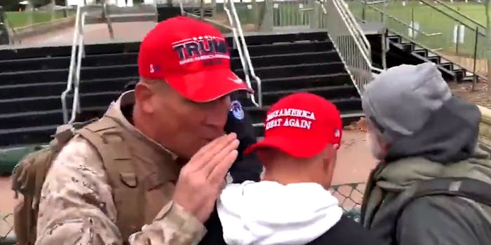 Man in Trump hat whispering to man in Make America Great Again hat