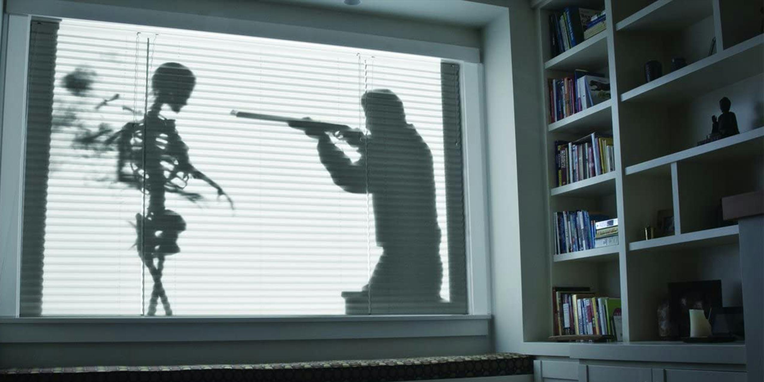 Man shooting skeleton from Shades of Evil AtmosFX DVD projected onto window blinds