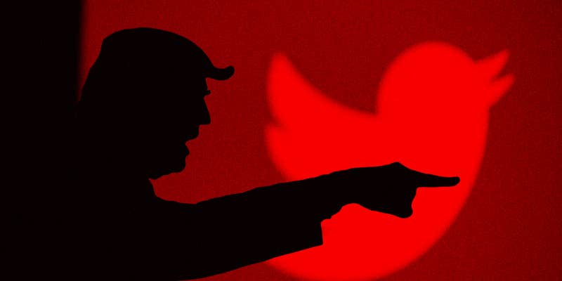 A man in silhouette pointing off camera.