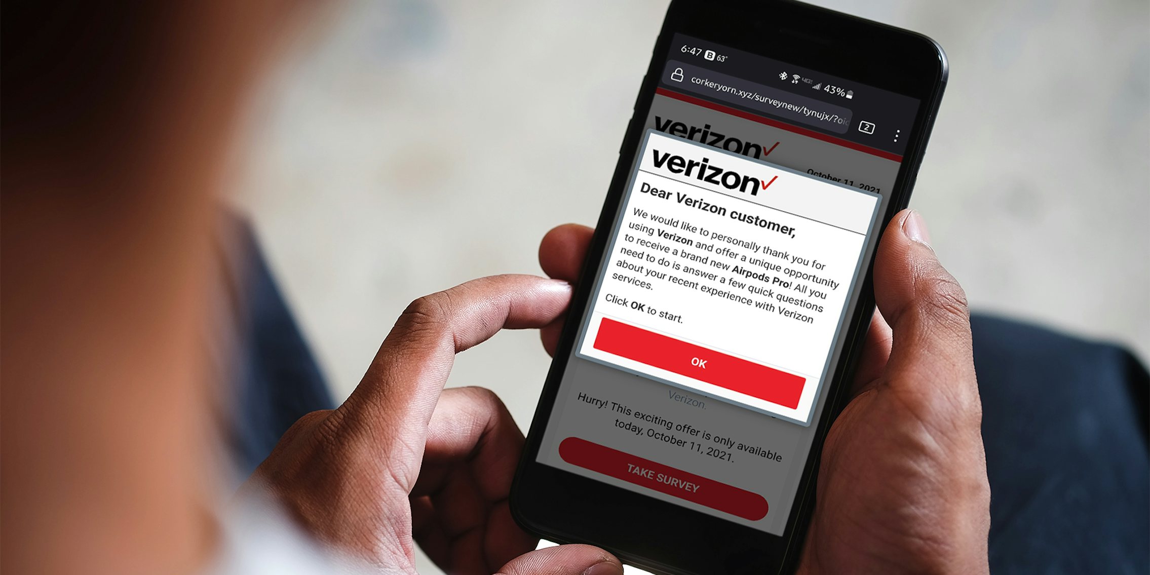 Person holding phone with Verizon scam text displayed on screen