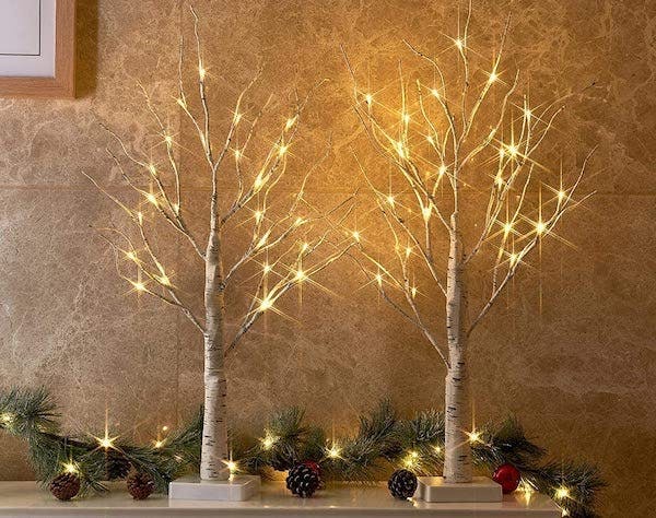 Christmas home decor: small light up birch trees sit on a mantel
