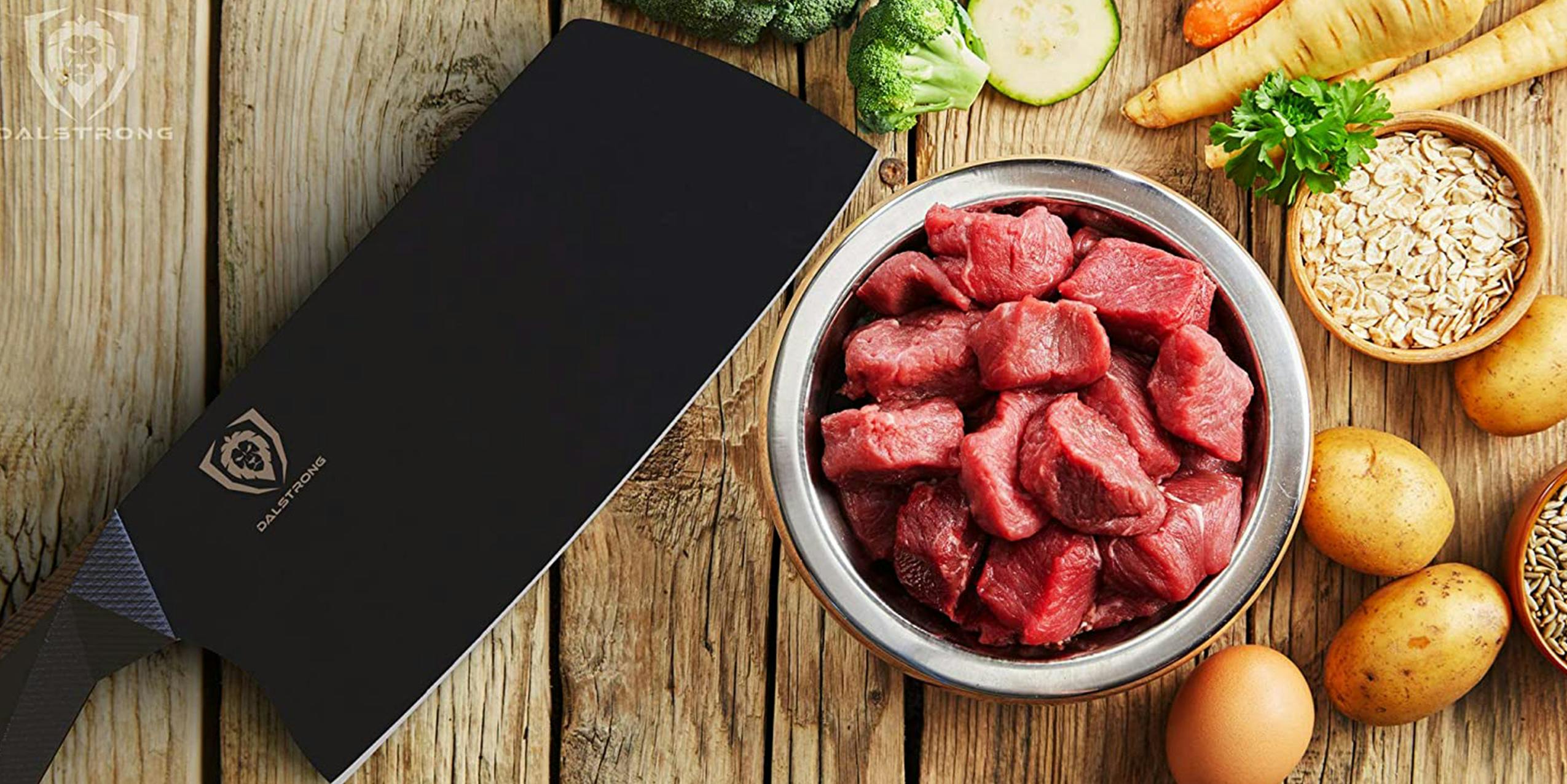 Dalstrong Shadow Black on a cutting board with chopped meat.