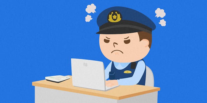 angry police officer sitting at laptop behind desk