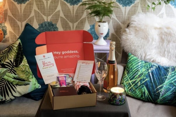 oh venus box - a box of toys, lotions, and romance ideas on a coffee table next to a candle