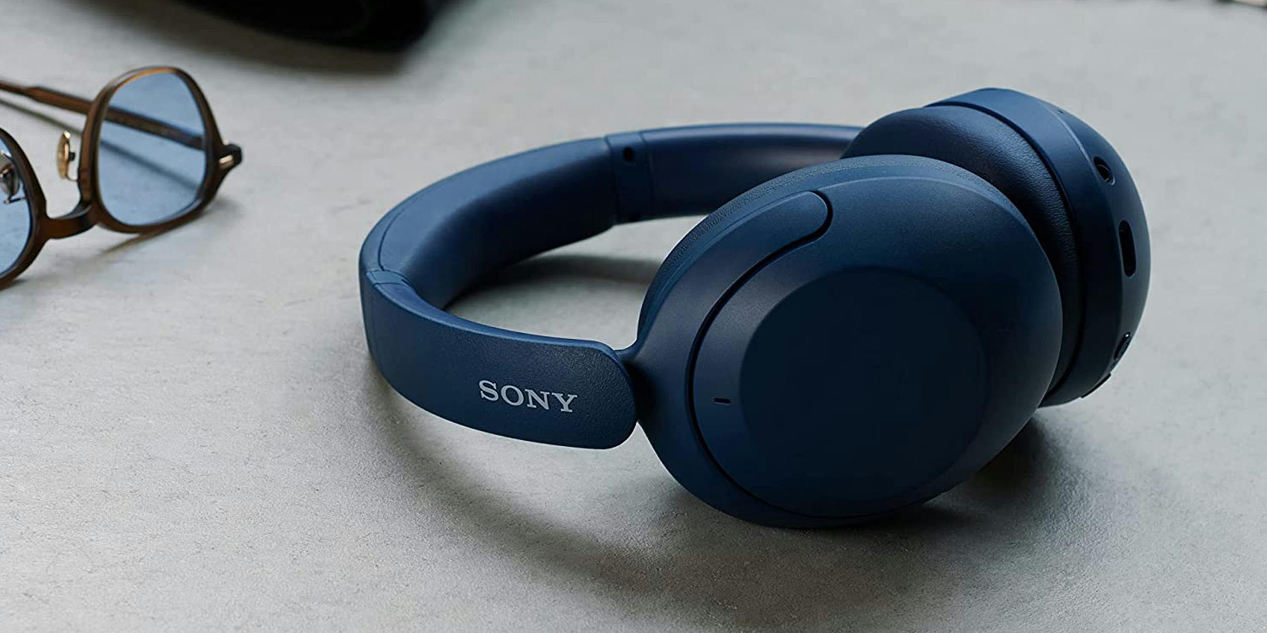 A pair of blue Sony Noise-Canceling Headphones on a desk.