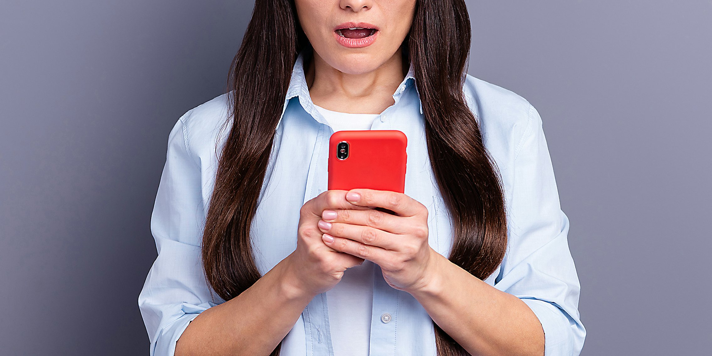 A woman in shock holding a phone.