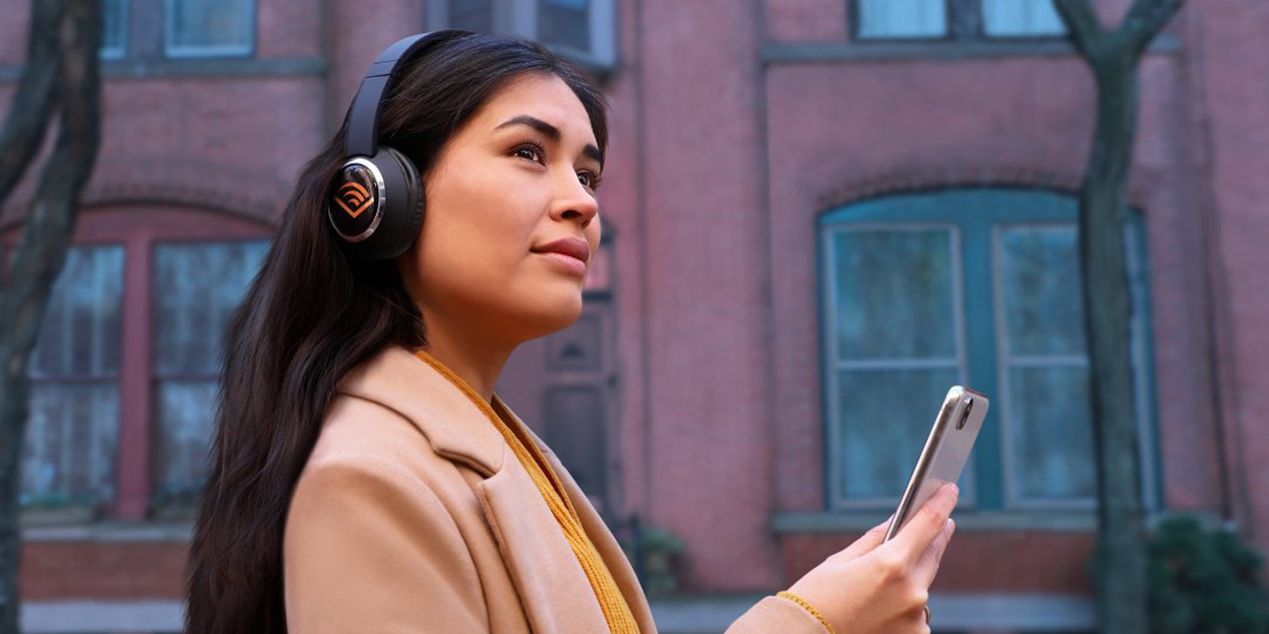 A woman listening to Audible audiobooks on headphones.