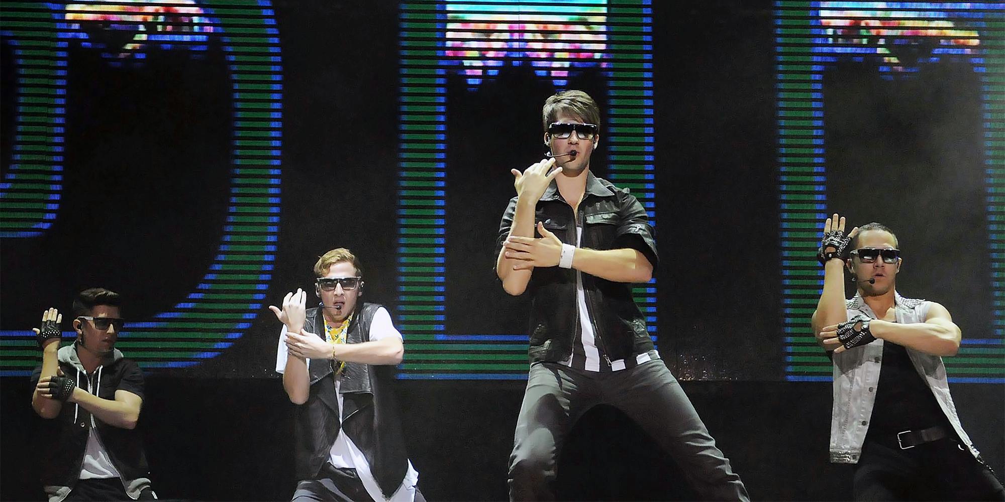 Four young men dance on stage