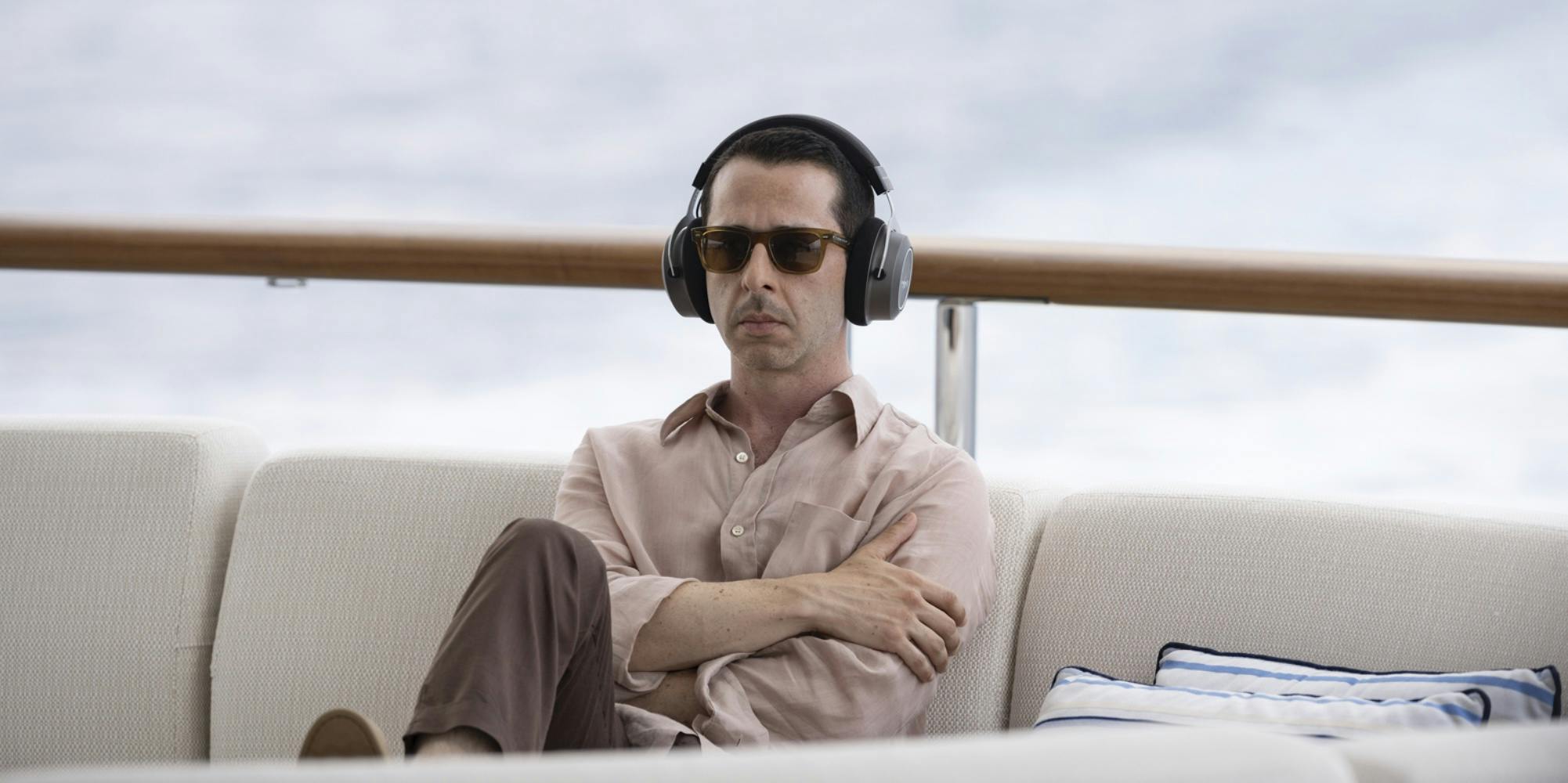 kendall roy (jeremy strong) sitting on a boat wearing headphones