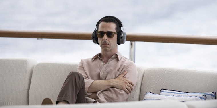 kendall roy (jeremy strong) sitting on a boat wearing headphones