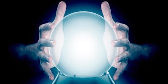一对围绕一个水晶球的男性双手在孤立的黑暗工作室背景上加入全息图
