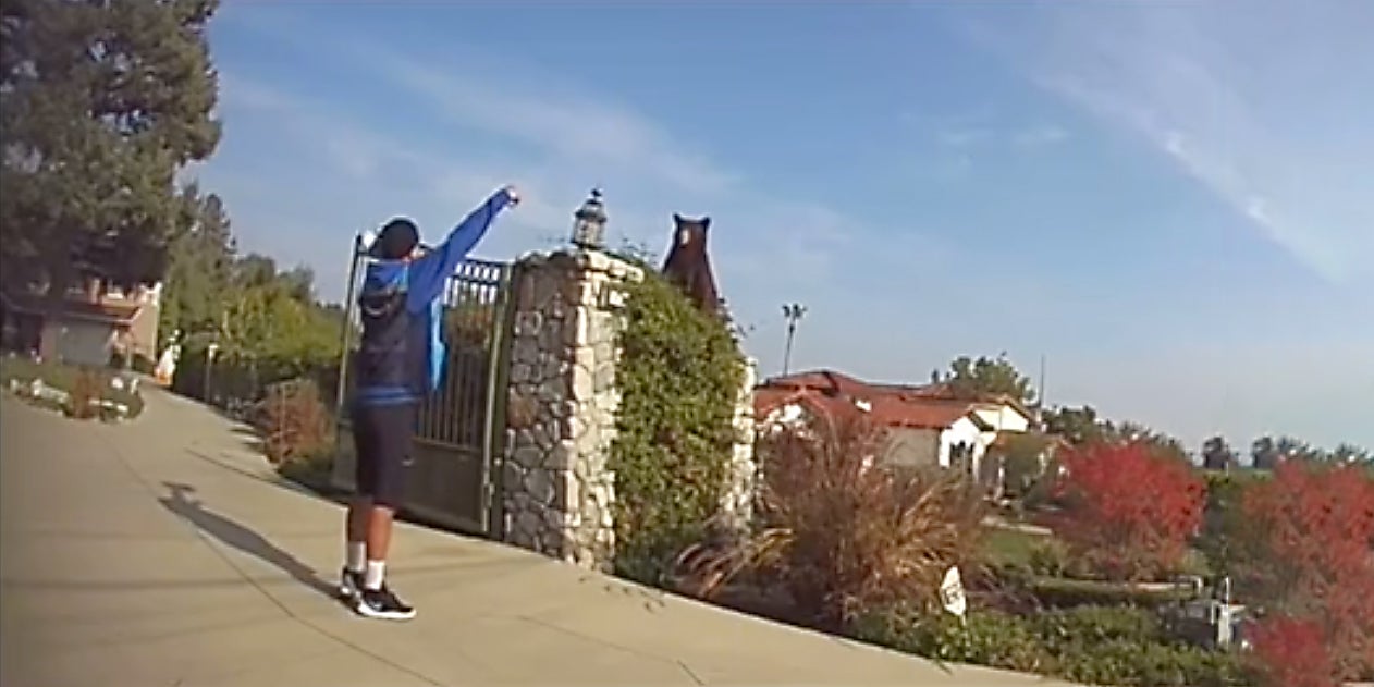 A man raising his arms to scare a bear.