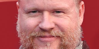 photo of joss whedon in front of a red background