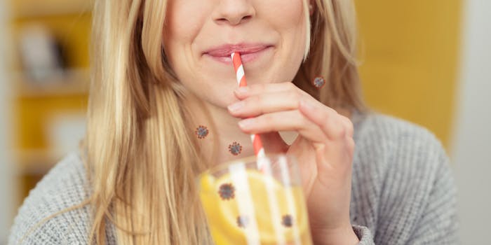 photo of a woman drinking a glass of lemonade that is filled with covid virus
