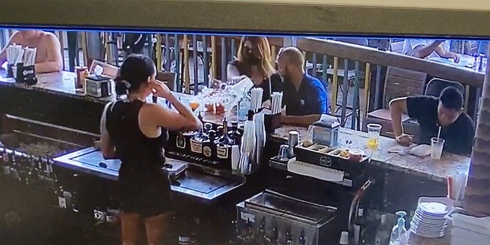 A woman throwing a drink at a bartender.