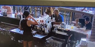 A woman throwing a drink at a bartender.