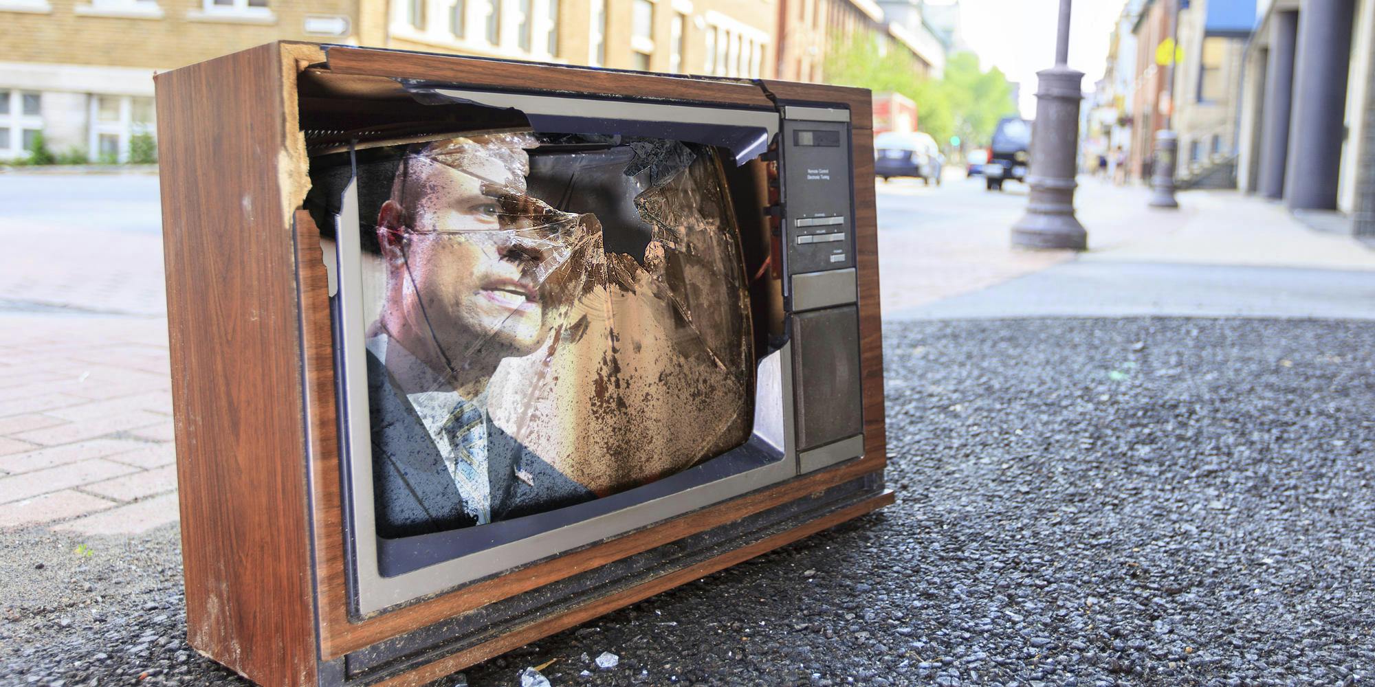 a television with a broken screen that shows dan bongino