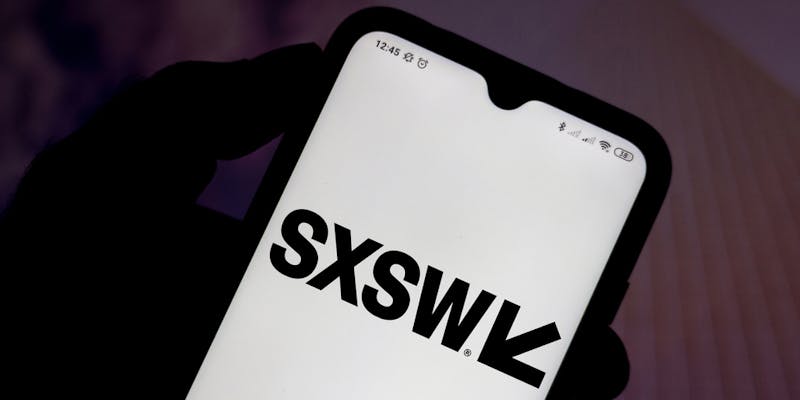 在这张照片中，南由西南（SXSW）徽标显示在智能手机屏幕上