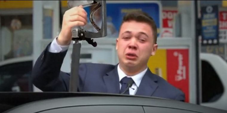 man crying holding gas pump up