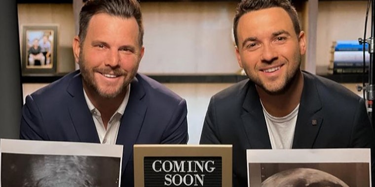 Dave Rubin and husband David in suits holding ultrasounds and sign that says 'coming soon'