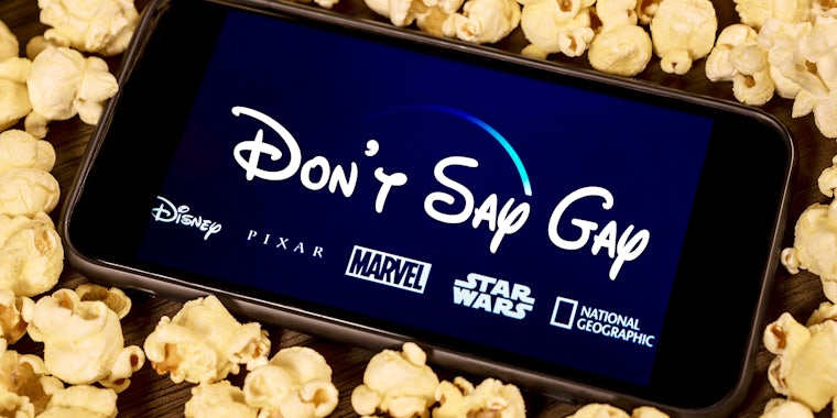 'Don't Say Gay' in Disney logo typeface on phone with popcorn