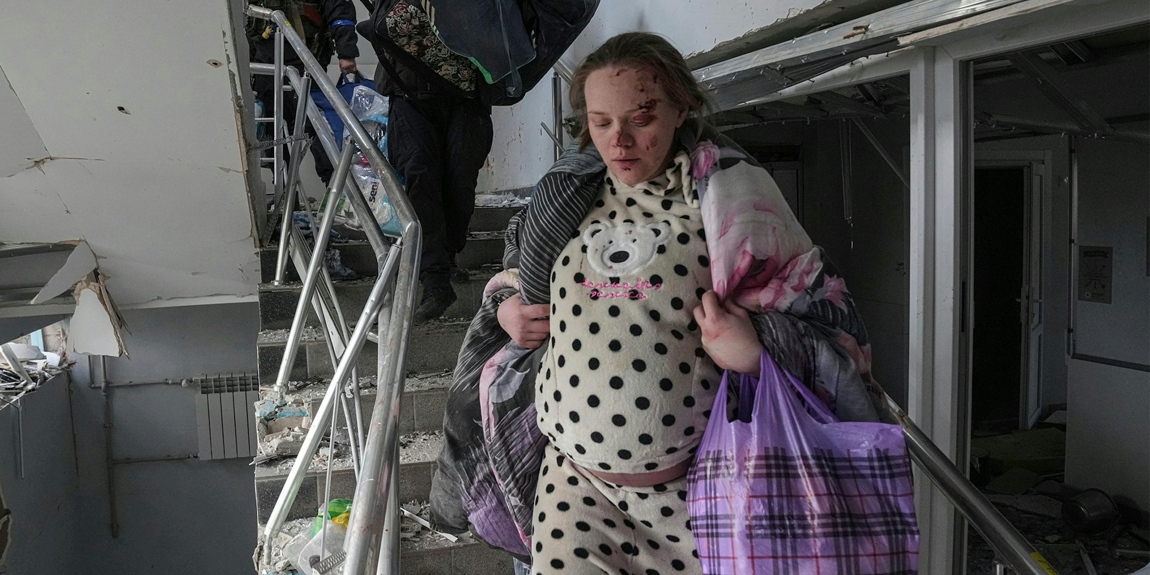 wounded pregnant woman leaving ruined building