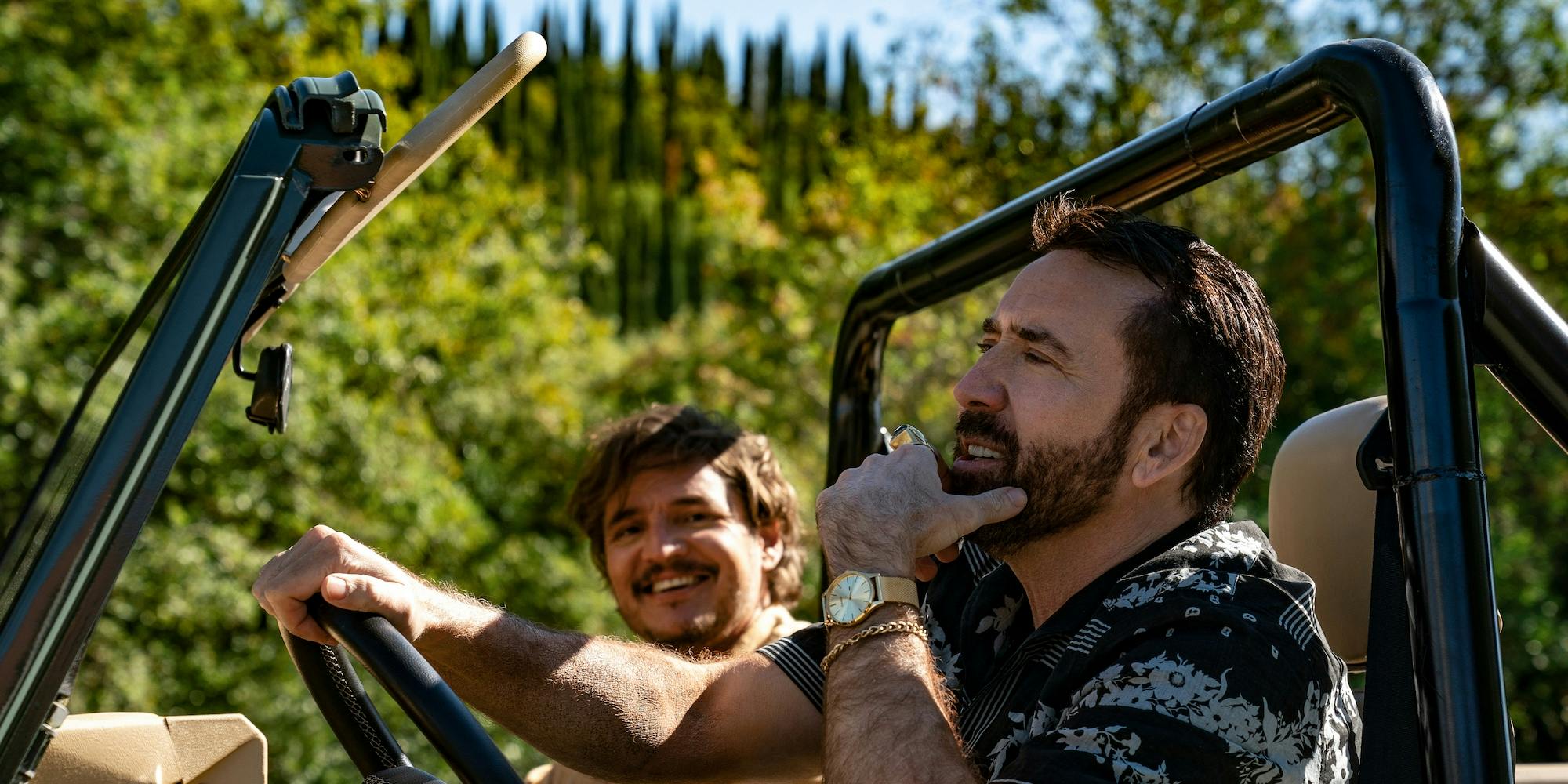 nicolas cage and pedro pascal in a jeep laughing