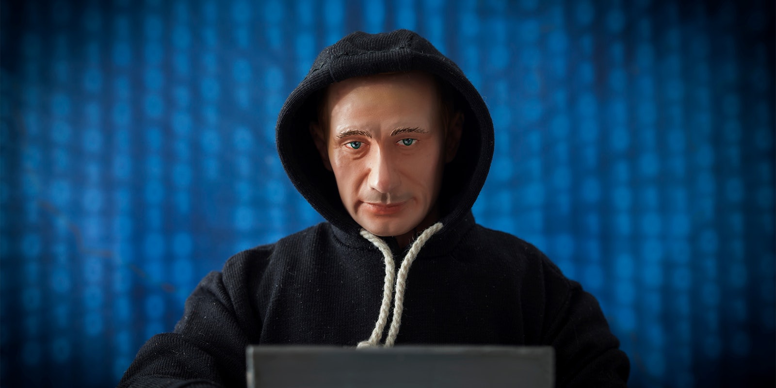 Caricature of Russian President Vladimir Putin in an election hacking concept - in a dark hoodie, at a laptop with binary code