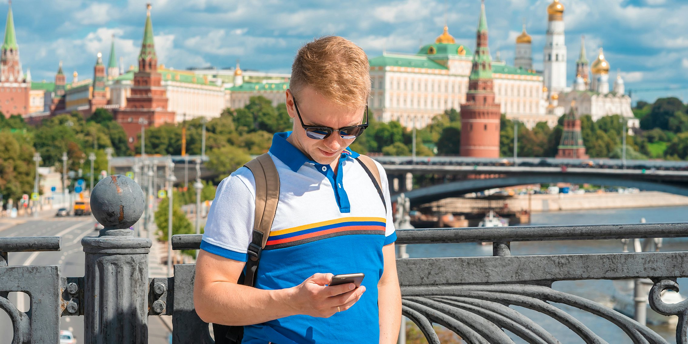 young man on phone in front of kremlin