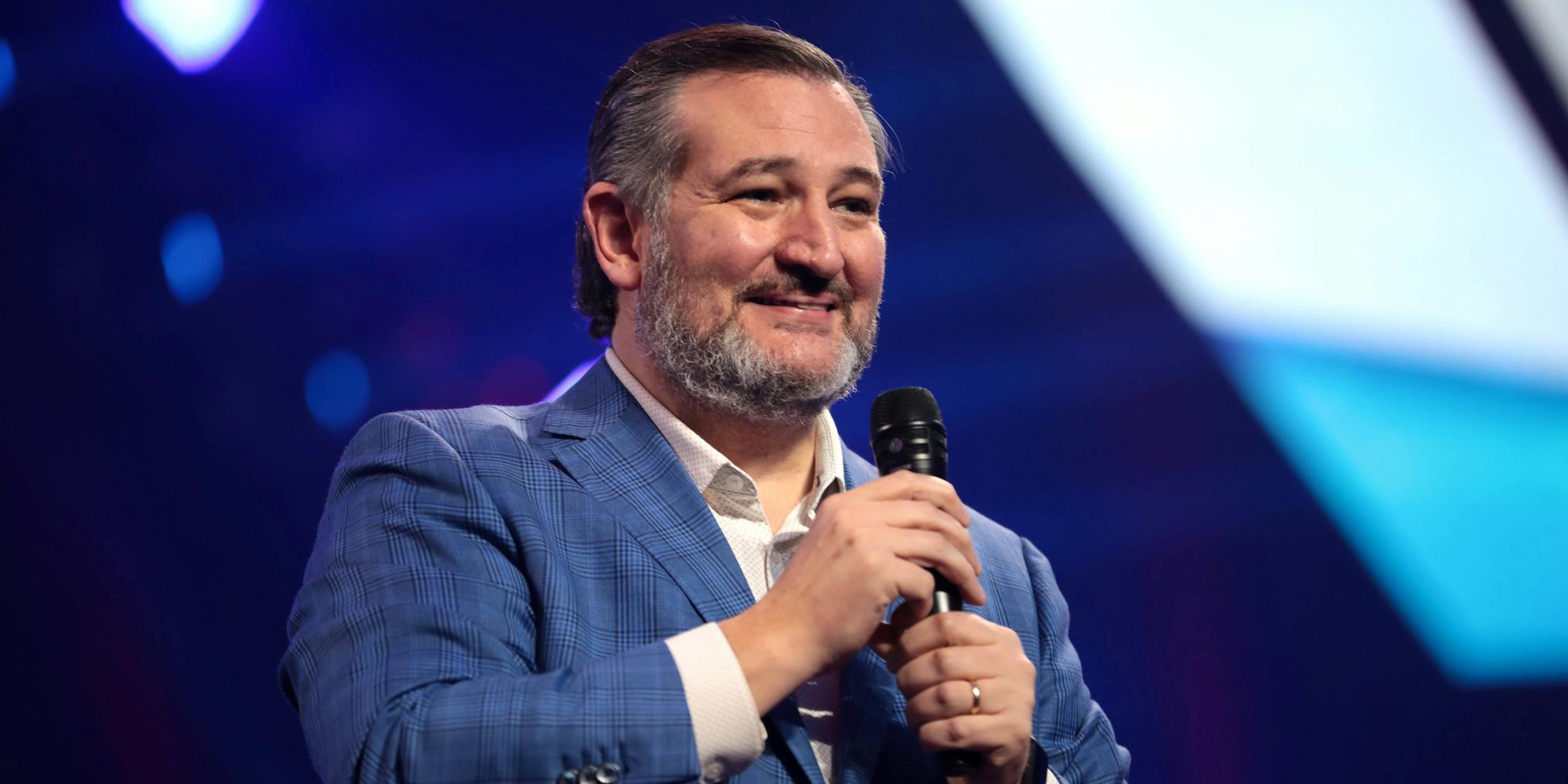 Sen. Ted Cruz smiling and holding a microphone.