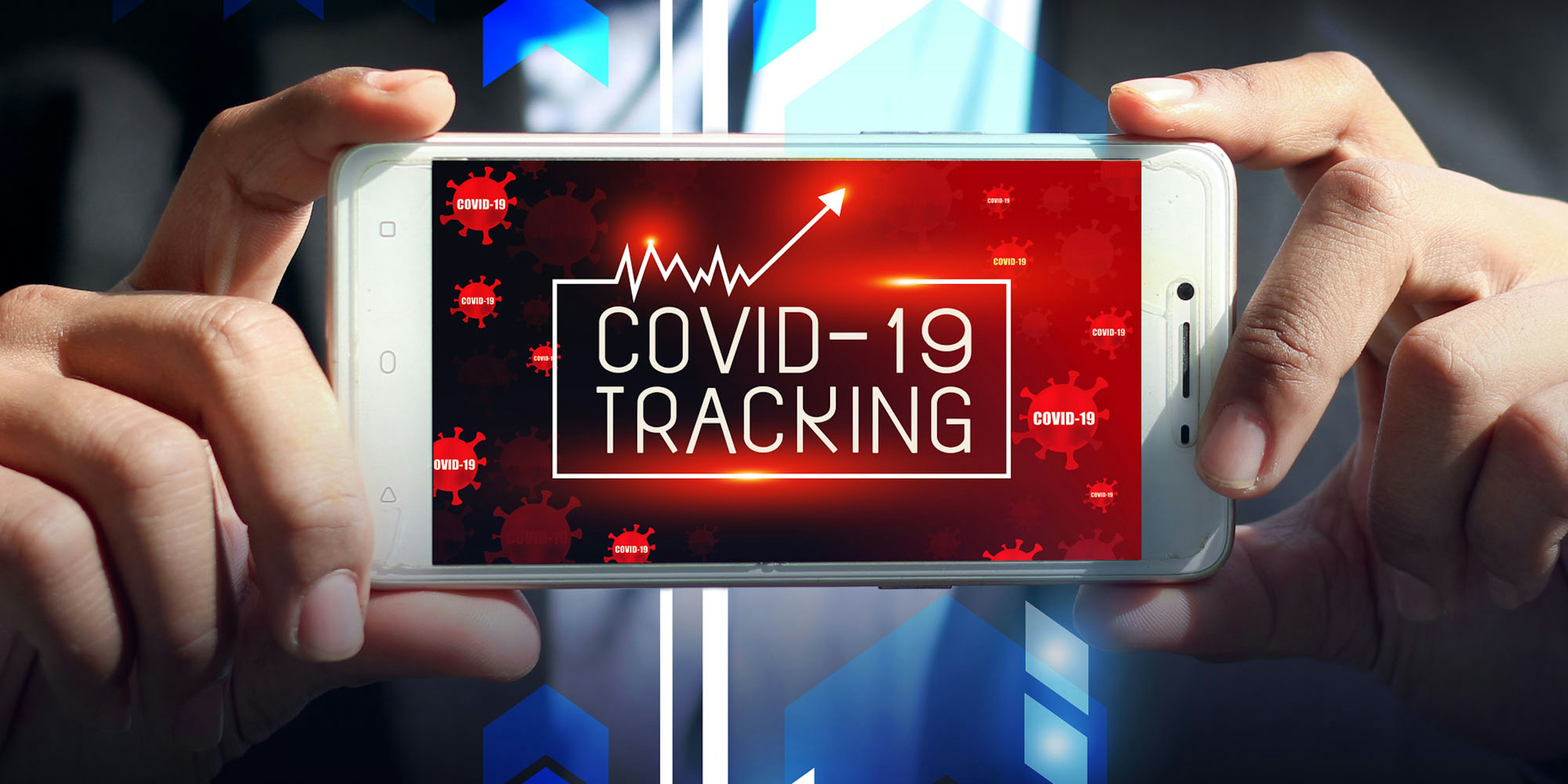 man in suit hands holding phone that says COVID-19 tracker
