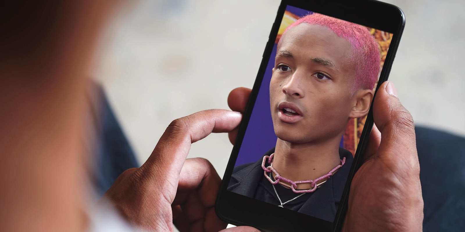 man holding smartphone with jaden smith displayed on the screen