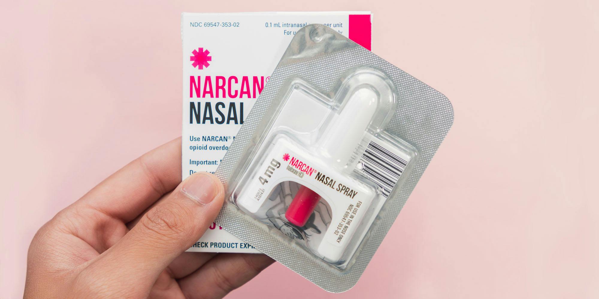 hand holding NARCAN NASAL SRAY on blush pink background