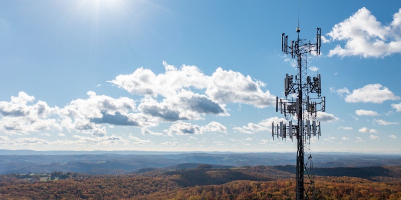 Aerial view of mobile phone cell tower over forested rural area