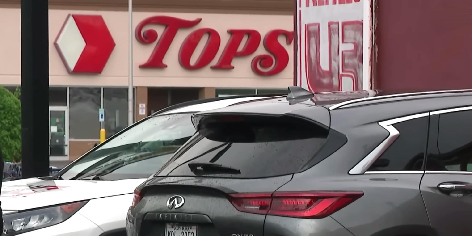 Two vehicles parked in front of a Tops store