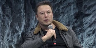 Elon Musk speaking into microphone textured grey background