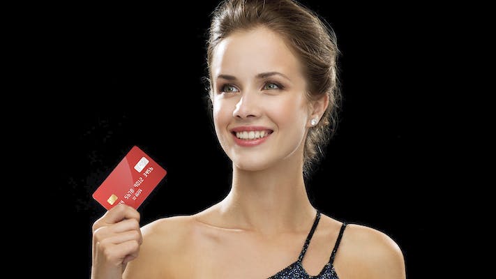 A woman holding a red credit card. This is an ad for the Daily Dot newsletter