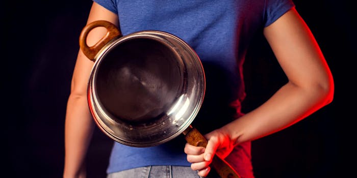 woman in blue shirt holding frying pan