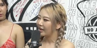 blonde asian woman speaking into a microphone