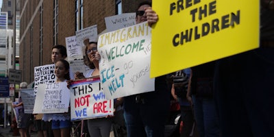 protesters with signs about ICE 'Free the children' 'Immigrants welcome, ICE- go melt yourself' It is inhumane to separate children from their families'