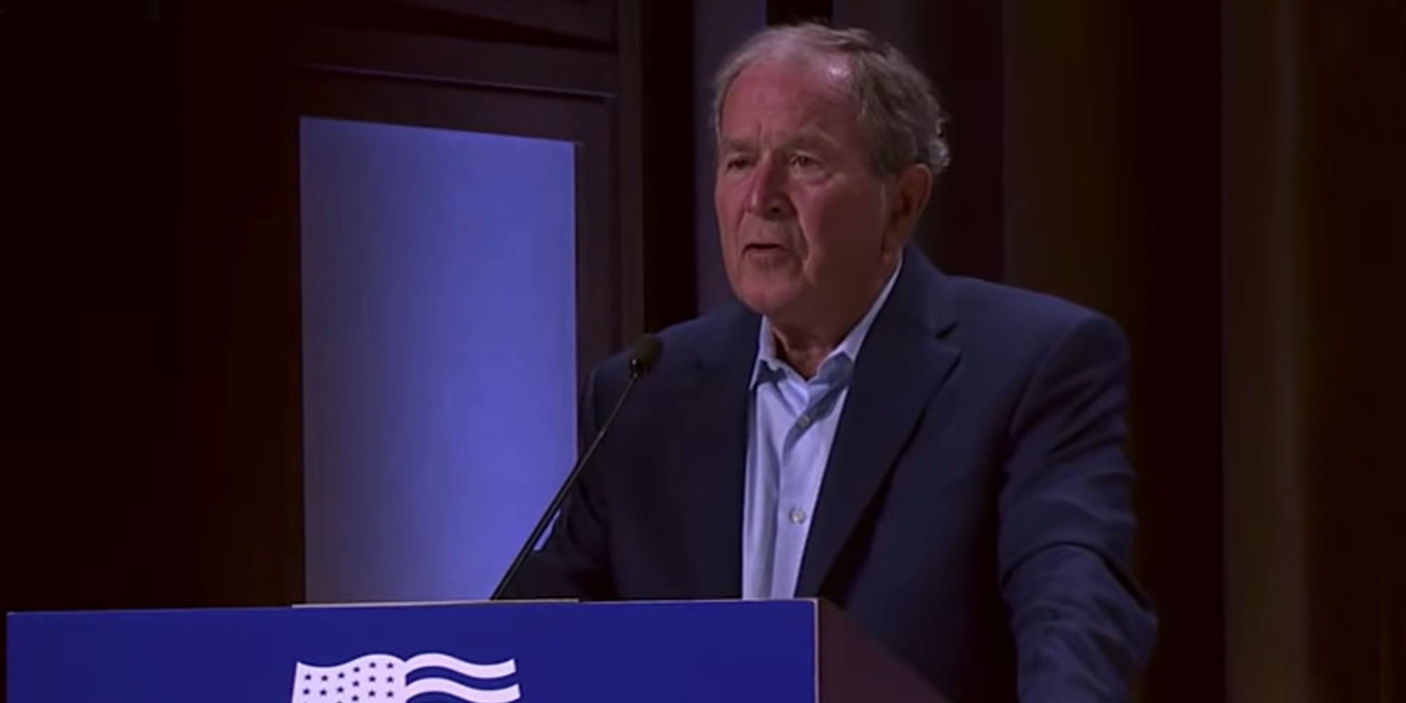 Former President George W Bush speaking into microphone