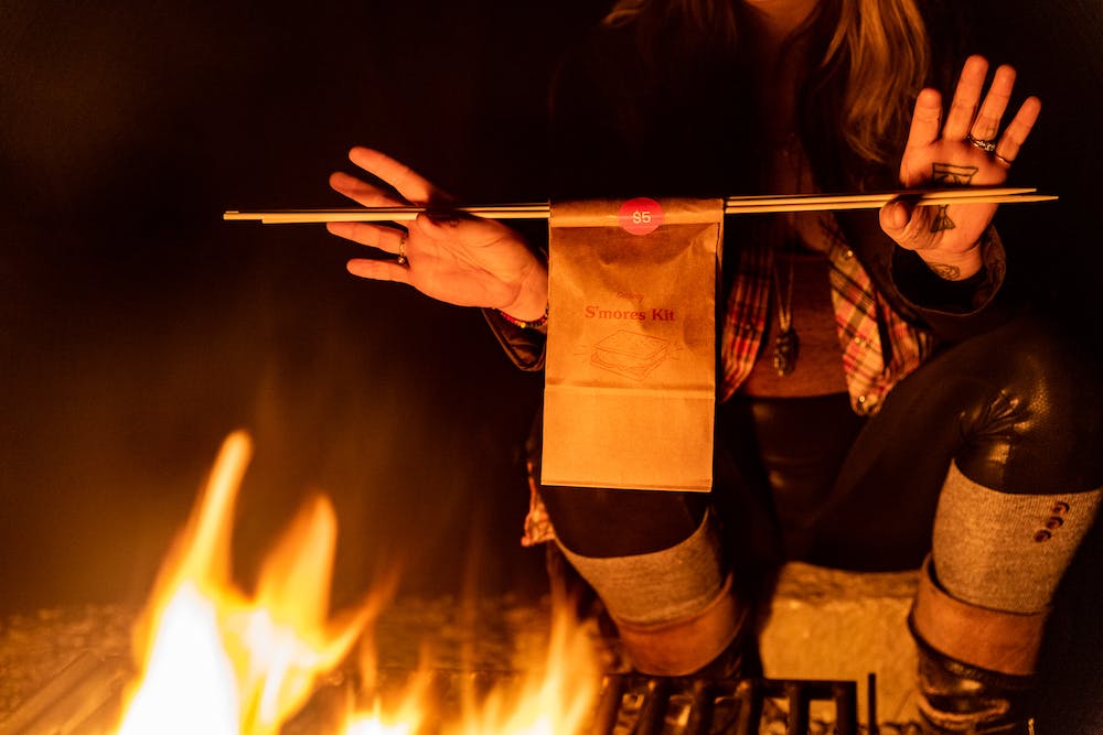 a woman with hand tattoos holding a Getaway house s'mores kit for $5